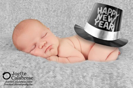 Schlafendes Baby mit "Happy New Year"-Hut auf Wolldecke